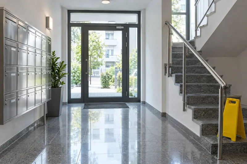 Frisch gereinigter Eingangsbereich mit Briefkastenanlage, Glastür und Treppe